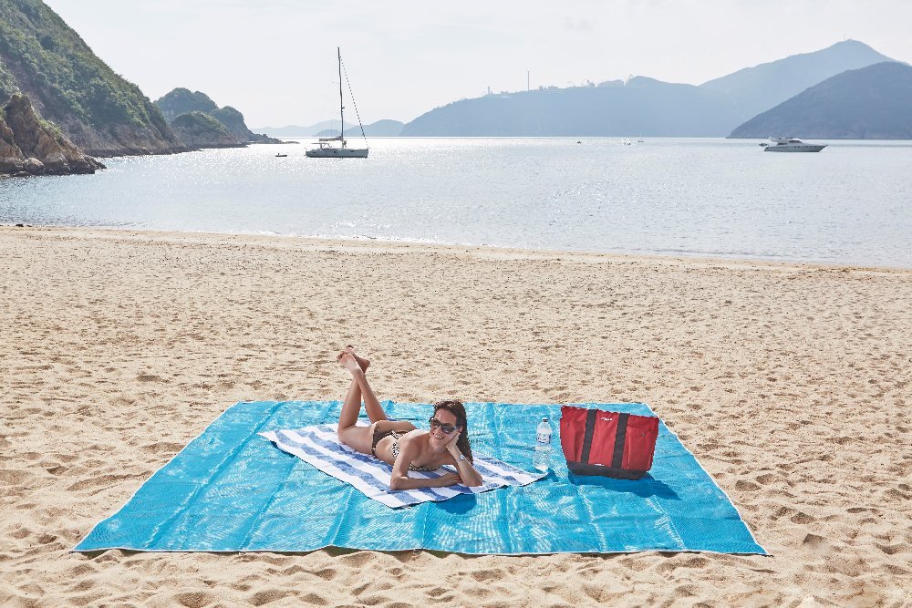 Woman Using A Sand-Free Beach Mat On The Beach