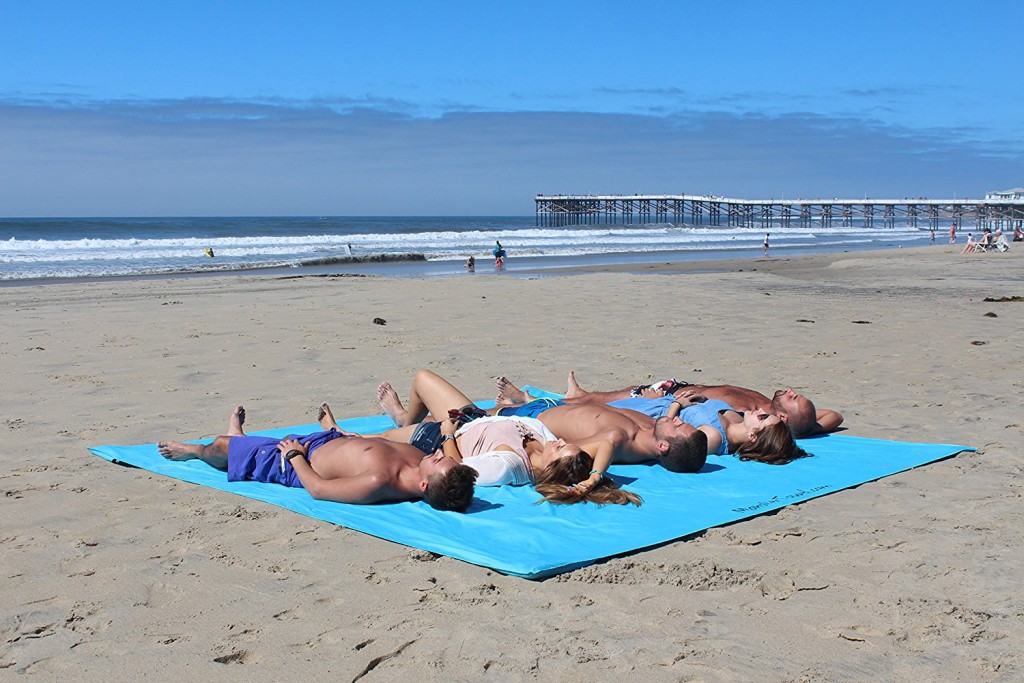 5 People Lying On The Monster Towel At The Beach